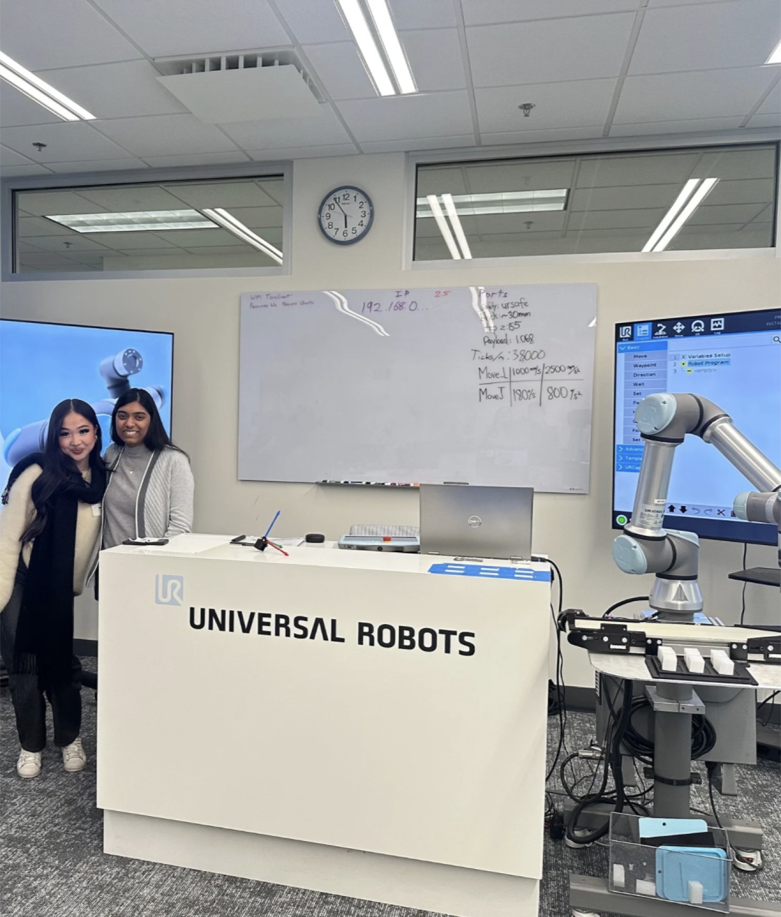 Veronika Wang at Universal Robots beside a collaborative robot arm and a whiteboard of program parameters
